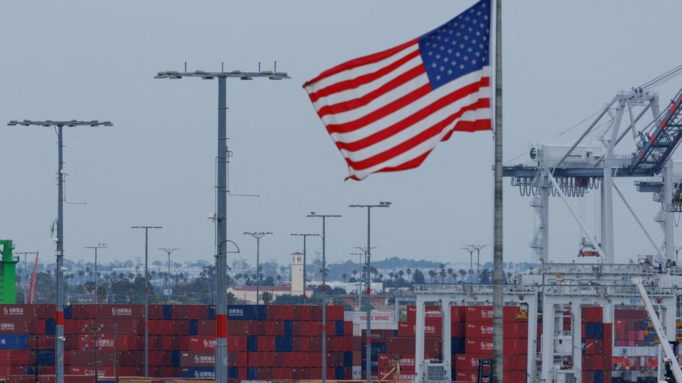 A U.S. flag flutters near Chinese shipping containers at the Port of Los Angeles, in San Pedro, California, U.S., May 1, 2025. REUTERS/Mike Blake