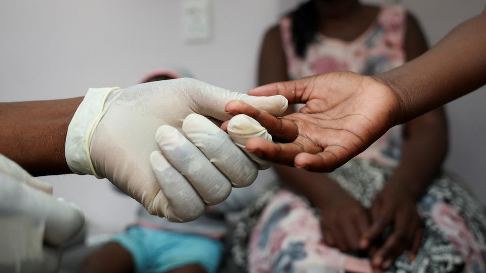 A nurse takes a blood sample from a child for an HIV test while the child's mother looks on at a clinic in Diepsloot, north of Johannesburg, South Africa, March 12, 2025. REUTERS/Siphiwe Sibeko