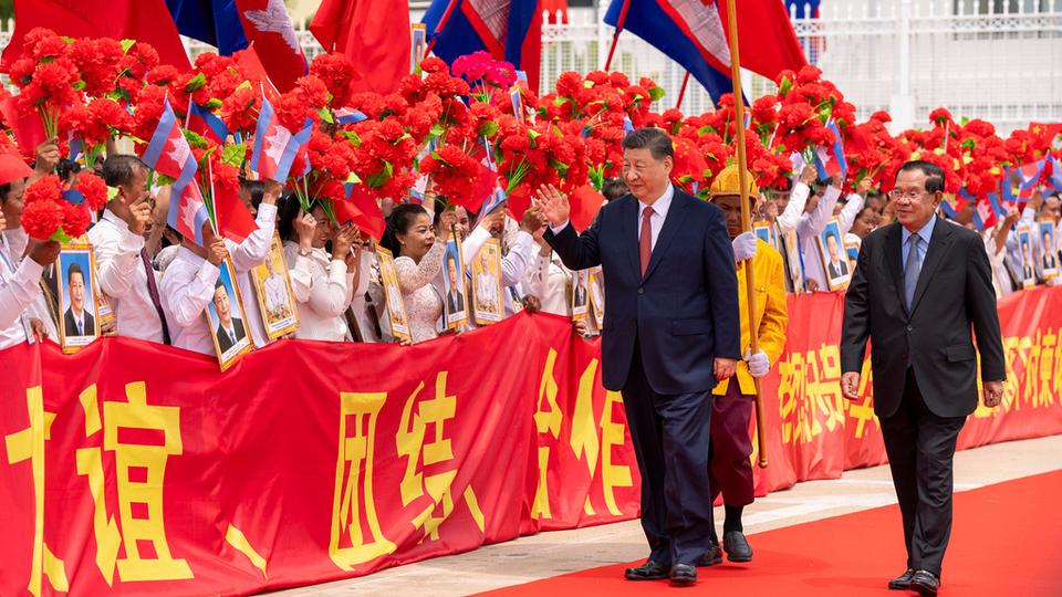 In this photo released by Agence Kampuchea Press (AKP), Chinese President Xi Jingping, left on the carpet, greets the crowd as he is accompanied by Cambodian Senate President Hun Sen, right, during a send-off ceremony at Phnom Penh International Airport in Phnom Penh, Cambodia, Friday, April 18, 2025. (AKP via AP)