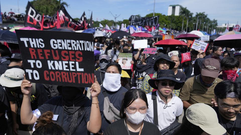Protesters carry signs as they march during a rally against government corruption at the EDSA People Power Monument in suburban Mandaluyong, east of Manila, Philippines, Sunday. Sept. 21, 2025. (AP Photo/Basilio Sepe)