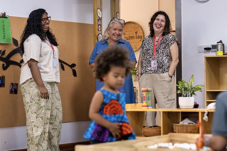 Daun (right) visits a Nursery classroom at CIS’s Bassac Garden Campus.