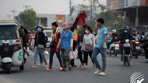 Factory workers cross a busy street after their shift in Phnom Penh, Cambodia, on a recent evening. Many workers rely on low wages while navigating challenging commutes and rising economic pressures. Kiripost/Vann Chan Thada