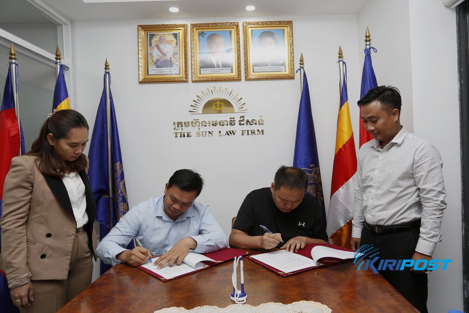 Taing Sambath, CEO and owner of Taing Eanghuot Rice Mill, signs the MoU with Dashravdan Baljinnyam, a researcher at Eastern Partnership Business Council in Phnom Penh, October 19, 2022. Kiripost/Siv Channa