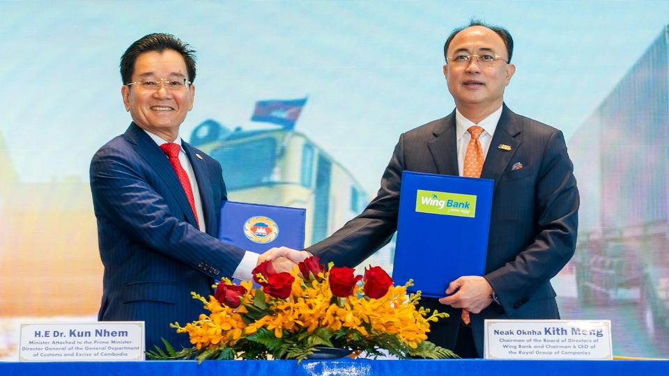 H.E. Dr. Kun Nhem and Neak Oknha Kith Meng preside over the MoU signing to promote e-payment services.