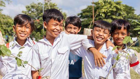 The five students hold small plants with smile. Kiripost/supplied